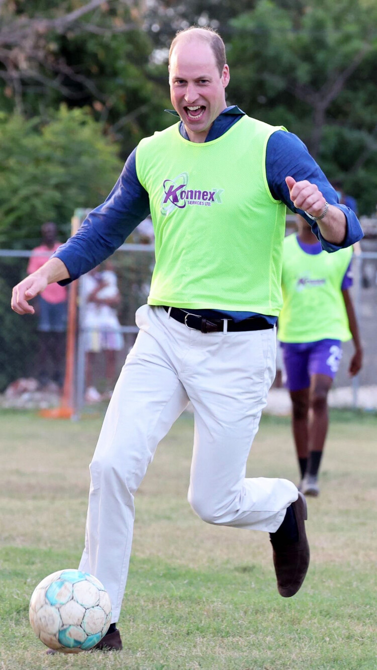 Принц Уильям, герцог Кембриджский, играет в футбол во время визита в Тренч-Таун 22 марта 2022 года в Кингстоне, Ямайка